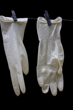 Vertical Closeup Shot Of White Plastic Gloves Hanging On A Rope