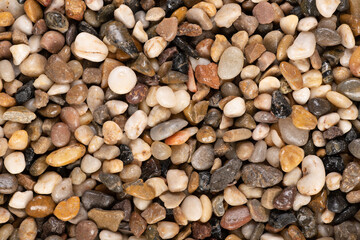Multi-colored small river stones texture and background.