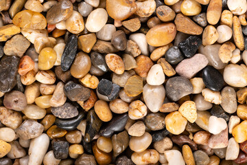Multi-colored small river stones texture and background.