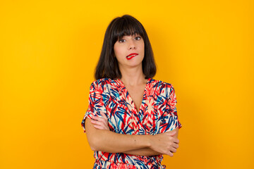 Isolated portrait of stylish young European woman bitting her mouth and looking worried and scared crossing arms, worry and doubt.