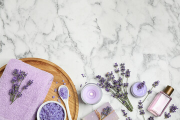 Cosmetic products and lavender flowers on white marble table, flat lay. Space for text