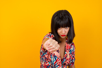 Discontent European woman shows disapproval sign, keeps thumb down, expresses dislike, frowns face...