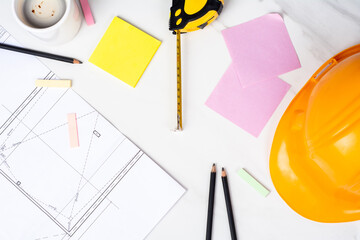 Blueprints, measuring tape and helmet.