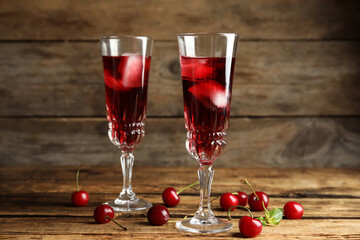 Delicious cherry wine with ripe juicy berries on wooden table