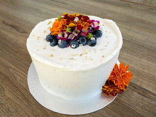 white gluten free cake with flowers and berrys 