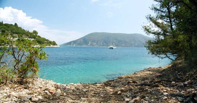 Beautiful landscape with green forest and emerald water lagoon of Foki Fiskardo beach, Kefalonia, Ionian islands, Greece.