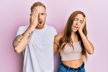 Young couple of girlfriend and boyfriend hugging and standing together yawning tired covering half face, eye and mouth with hand. face hurts in pain.