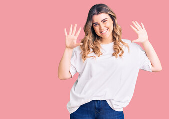 Fototapeta na wymiar Young caucasian woman wearing casual clothes showing and pointing up with fingers number ten while smiling confident and happy.
