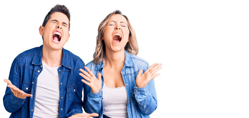 Fototapeta premium Couple of women wearing casual clothes celebrating mad and crazy for success with arms raised and closed eyes screaming excited. winner concept