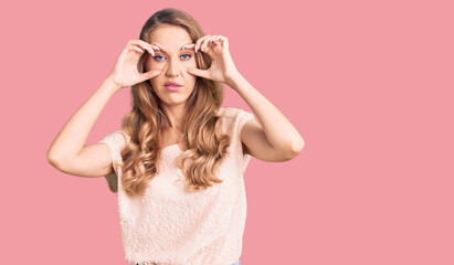 Young beautiful caucasian woman with blond hair wearing casual clothes trying to open eyes with fingers, sleepy and tired for morning fatigue