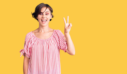 Beautiful young woman with short hair wearing casual summer clothes showing and pointing up with fingers number two while smiling confident and happy.