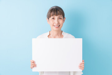 ホワイトボードを持つシニア女性　笑顔 - obrazy, fototapety, plakaty