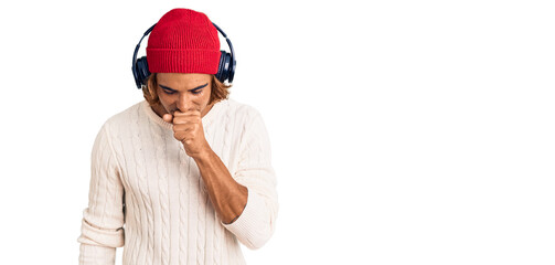 Young hispanic man listening to music using headphones feeling unwell and coughing as symptom for cold or bronchitis. health care concept.