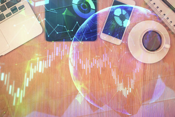 Double exposure of financial chart hologram over desktop with phone. Top view. Mobile trade platform concept.