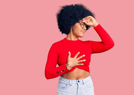 Young african american girl wearing casual clothes and glasses touching forehead for illness and fever, flu and cold, virus sick