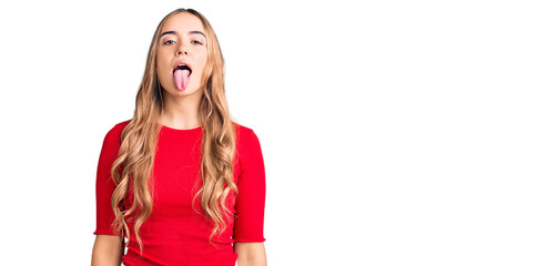 Young beautiful blonde woman wearing casual clothes sticking tongue out happy with funny expression. emotion concept.