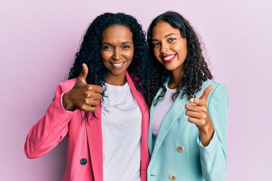 African american mother and daughter wearing business style pointing fingers to camera with happy and funny face. good energy and vibes.