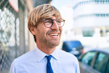 Caucasian business man wearing suit and tie smiling happy outdoors