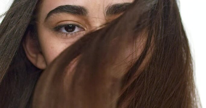 Close up of a girl's eyes with her hair blowing behind her.