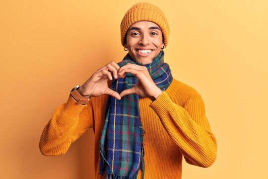 Young african amercian man wearing casual winter clothes smiling in love showing heart symbol and shape with hands. romantic concept.