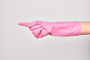 Hand of caucasian young woman wearing pink cleaning glove. Pointing with index finger showing number one over isolated white background