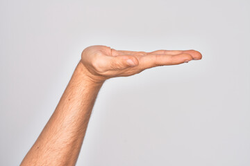 Hand of caucasian young man showing fingers over isolated white background with flat palm presenting product, offer and giving gesture, blank copy space