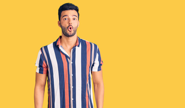 Young handsome hispanic man wearing casual  summer shirt scared and amazed with open mouth for surprise, disbelief face