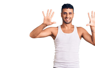 Fototapeta premium Young hispanic man wearing casual clothes showing and pointing up with fingers number ten while smiling confident and happy.