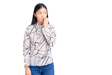 Young beautiful chinese woman wearing casual shirt looking stressed and nervous with hands on mouth biting nails. anxiety problem.