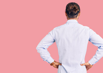 Young handsome man wearing business clothes standing backwards looking away with arms on body