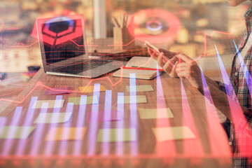 Double exposure of woman hands working on computer and forex graph hologram drawing. Financial...