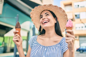 Young latin tourist girl on vacation smiling happy eating ice cream at the city.