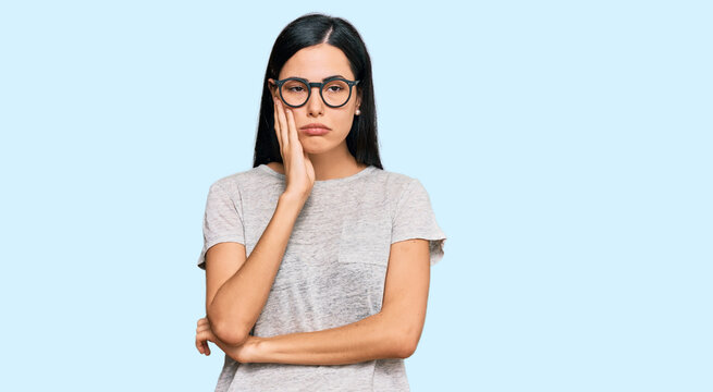 Beautiful young woman wearing casual clothes and glasses thinking looking tired and bored with depression problems with crossed arms.