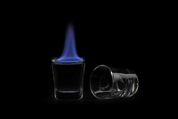 Low-key flaming shot drink. Ethanol blue flame.