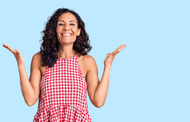 Fototapeta premium Middle age beautiful woman wearing casual sleeveless t shirt celebrating mad and crazy for success with arms raised and closed eyes screaming excited. winner concept