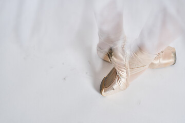 Ballerina in a white tutu dance performed on a light background
