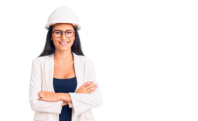 Young beautiful latin girl wearing architect hardhat and glasses happy face smiling with crossed arms looking at the camera. positive person.