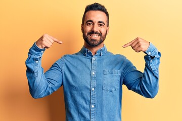 Young hispanic man wearing casual clothes looking confident with smile on face, pointing oneself with fingers proud and happy.