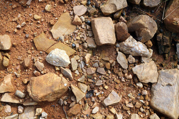 Wet ground, yellow soil, there are many small stones, details of the texture