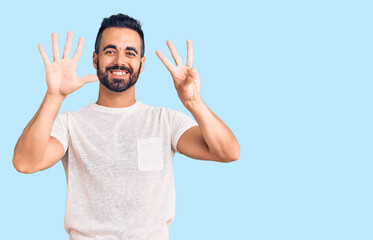 Fototapeta premium Young hispanic man wearing casual clothes showing and pointing up with fingers number eight while smiling confident and happy.