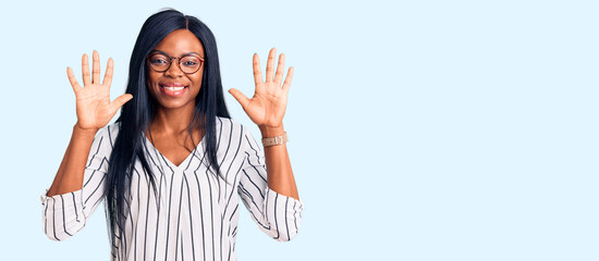 Fototapeta na wymiar Young african american woman wearing casual clothes and glasses showing and pointing up with fingers number ten while smiling confident and happy.