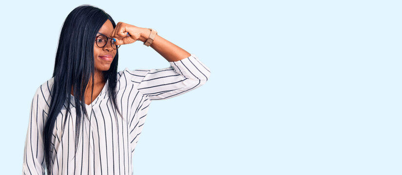 Young african american woman wearing casual clothes and glasses strong person showing arm muscle, confident and proud of power