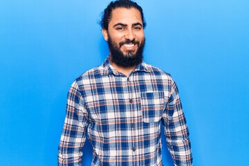 Fototapeta premium Young arab man wearing casual clothes looking positive and happy standing and smiling with a confident smile showing teeth