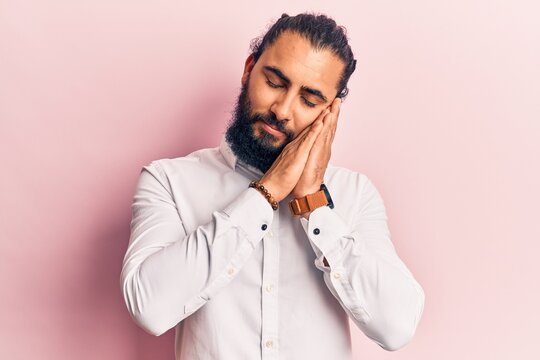 Young arab man wearing casual clothes sleeping tired dreaming and posing with hands together while smiling with closed eyes.