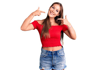 Obraz na płótnie Canvas Young beautiful hispanic woman wearing casual clothes smiling cheerful showing and pointing with fingers teeth and mouth. dental health concept.