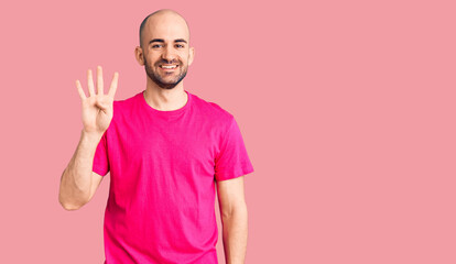 Young handsome man wearing casual t shirt showing and pointing up with fingers number four while smiling confident and happy.