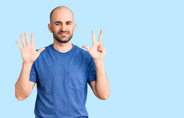 Naklejka premium Young handsome man wearing casual t shirt showing and pointing up with fingers number eight while smiling confident and happy.