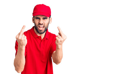 Fototapeta na wymiar Young handsome man with beard wearing delivery uniform showing middle finger doing fuck you bad expression, provocation and rude attitude. screaming excited