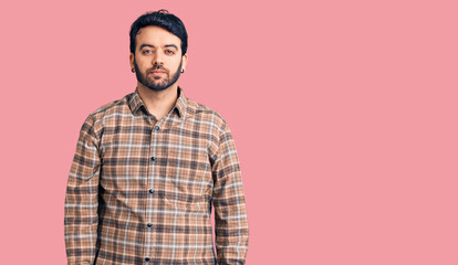 Young hispanic man wearing casual clothes relaxed with serious expression on face. simple and natural looking at the camera.
