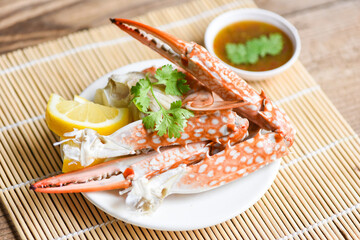 Boiled crab food on white plate and seafood sauce on the table - crab claws shellfish